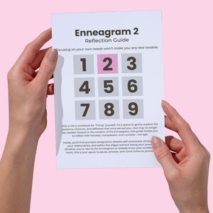 Può includere: Una guida di riflessione Enneagramma 2 bianca con sfondo rosa. La guida presenta una griglia di numeri, con il numero 2 evidenziato in rosa. Il testo sulla guida incoraggia l'autoriflessione e la consapevolezza di sé.