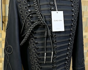 May include: A black military-style jacket featuring intricate black cord braiding, a high collar, and multiple black spherical buttons. A braided cord with silver-toned metal tips hangs from the shoulder. A white tag displays the text EURO ERA.