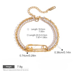 Könnte beinhalten: Goldfarbenes Armband mit Sicherheitsnadel-Design. Das Armband hat zwei Reihen klarer, quadratisch geschliffener Steine und ist 18,0 cm lang. Die Sicherheitsnadel ist 0,74 cm breit. Das Gewicht beträgt 7,8 Gramm.