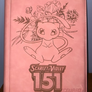 Puede incluir: Carpeta rosa para tarjetas coleccionables con diseño floral y personaje de dibujos animados. La portada incluye el texto "Scarlet & Violet 151" y "TCG Guard". La carpeta está diseñada para guardar tarjetas coleccionables.