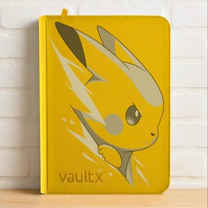 Op de afbeelding: Gele kaartenbinder met een Pikachu-ontwerp en bliksemeffect. De binder heeft een gele tab en het Vault X-logo is zichtbaar. De achtergrond is een witte bakstenen muur.