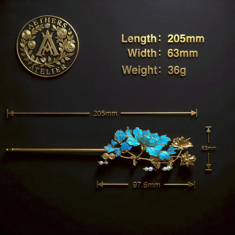 Pode incluir: Um gancho de cabelo dourado com detalhes florais em azul brilhante e pequenas contas brancas. O gancho mede 205 mm de comprimento, 63 mm de largura e pesa 36 g. Um log&oacute;tipo circular com o texto AETHERS ATELIER &eacute; vis&iacute;vel no canto superior esquerdo.