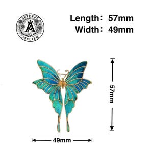 May include: A detailed butterfly brooch in shades of blue and gold. The brooch measures 5.7cm in length and 4.9cm in width. The image includes the text "Length: 57mm, Width: 49mm" and the Aethers Atelier logo.