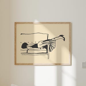 Puede incluir: Una impresión artística enmarcada con una ilustración minimalista de una persona reclinada en una silla. La obra de arte está realizada en líneas negras sobre un fondo crema, con la persona vestida con un vestido y tacones.