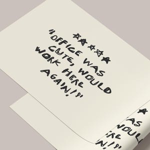 May include: Two off-white sheets of paper with handwritten text in black ink. The text reads "OFFICE WAS CUTE, WOULD WORK HERE AGAIN!" with star symbols. One sheet is partially rolled.