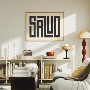 Puede incluir: Un cuadro enmarcado con la palabra "SALUD" en letras negras y gruesas. La obra de arte cuelga sobre una estanter&iacute;a con libros, una peque&ntilde;a radio y un cuenco decorativo. La habitaci&oacute;n tiene una est&eacute;tica moderna y minimalista.