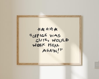 May include: A framed print with the text "OFFICE WAS CUTE, WOULD WORK HERE AGAIN!" in black handwritten font. Above the text are five black stars. The frame is a light brown color.