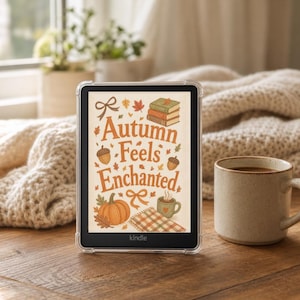 Puede incluir: Un lector electrónico Kindle en una funda protectora transparente que muestra un gráfico en pantalla con el texto Autumn Feels Enchanted, rodeado de ilustraciones de una pila de libros, bellotas, una calabaza, una manta a cuadros y una taza.