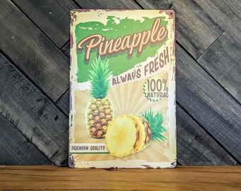 May include: A vintage-style metal sign featuring a pineapple illustration. The sign reads "Pineapple Always Fresh 100% Natural Premium Quality" in a retro font. The sign has a distressed, aged appearance with a green and beige color scheme.