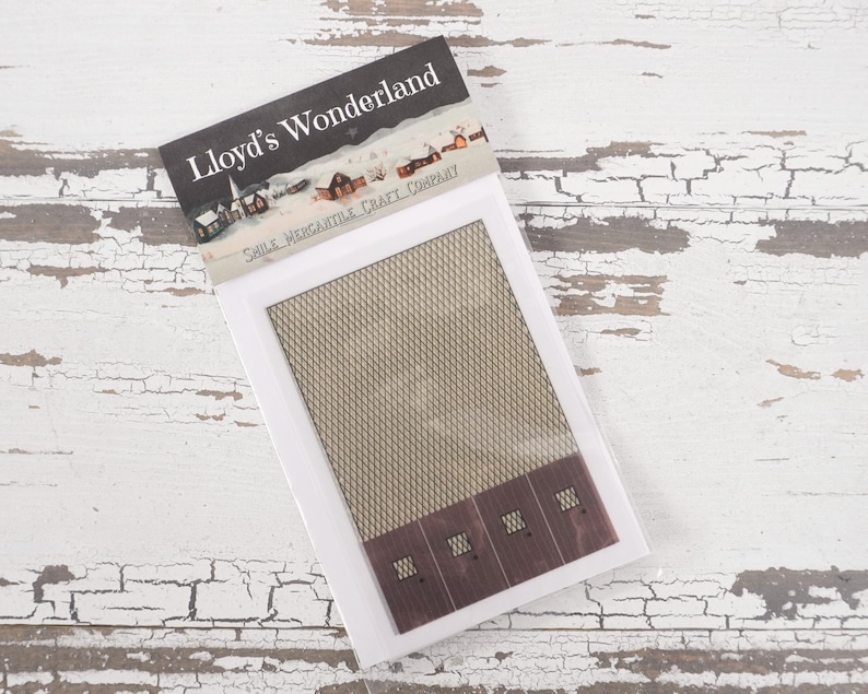 May include: A white package with a brown and white patterned design. The package has the text "Lloyd's Wonderland" and "Small Miniature Craft Company" printed on it. The package contains a miniature building with a brown roof and white walls.