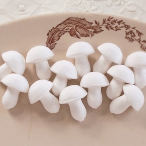 May include: A collection of white foam mushrooms on a beige plate with a brown floral design.
