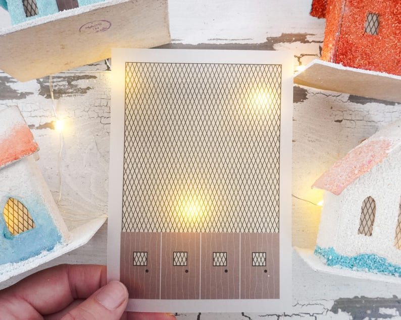 May include: A printable craft template for a miniature house with a brown wood-look base and a black wire mesh pattern on the front. The template has four windows with black frames.