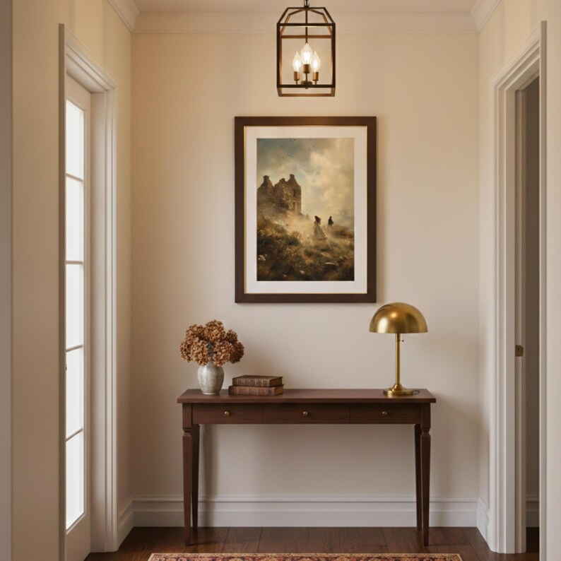 Puede incluir: Una mesa consola de madera oscura con tres cajones, sobre la cual hay un jarr&oacute;n con flores secas, dos libros apilados y una l&aacute;mpara de c&uacute;pula de lat&oacute;n. Sobre la mesa cuelgan un cuadro de paisaje enmarcado y una l&aacute;mpara de techo de metal negro.