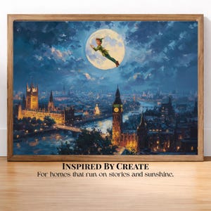 Peut inclure: Une impression d'art encadrée représentant une scène nocturne au-dessus de Londres avec une pleine lune et une silhouette volant devant. L'horizon urbain montre le Parlement et Big Ben illuminés sous un ciel bleu sombre. Texte : INSPIRED BY CREATE. For homes that run on stories and sunshine.