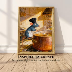 May include: A framed wall art print featuring a blue rat wearing a black chef hat and white apron, stirring a large copper pot of soup with a silver ladle. The text below the frame reads: INSPIRED BY CREATE For homes that run on stories and sunshine.