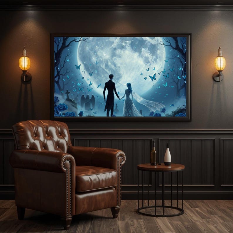 May include: A framed wall art print depicting a couple in formal attire holding hands before a large full moon, surrounded by blue butterflies, dark trees, and gravestones, displayed above a brown leather armchair and a small side table.