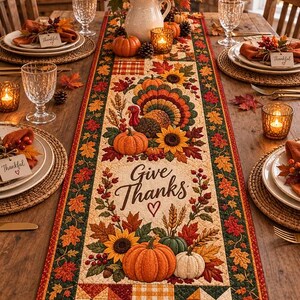 May include: A rectangular fabric table runner featuring a quilted design with a central turkey, pumpkins, sunflowers, and autumn leaves. The text "Give Thanks" with a heart is printed in the center, surrounded by a dark green border with leaf patterns.