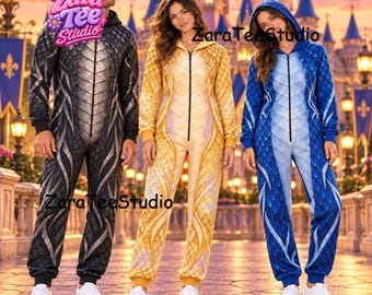 Op de afbeelding: Drie jumpsuits met capuchon en ritssluiting aan de voorzijde, voorzien van een draken-schubbenpatroon. Eén jumpsuit is zwart en grijs, één is geel en goud, en één is blauw en lichtblauw. Elk kledingstuk heeft lange mouwen en boorden.