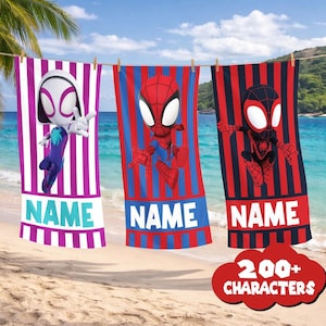 May include: Three beach towels with superhero designs hanging on a clothesline. One towel features Spider-Gwen, another Spider-Man, and the third Miles Morales. Each towel has a name section at the bottom and a striped background. The towels are hanging on a beach.