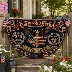 Peut inclure: Une tenture murale matelassée semi-circulaire représentant un pygargue à tête blanche, une croix et une carte des États-Unis. Le texte indique GOD BLESS AMERICA, 250 YEARS OF FREEDOM, ONE NATION UNDER GOD et 1776-2026. Deux petits drapeaux américains sont fixés sur les côtés.