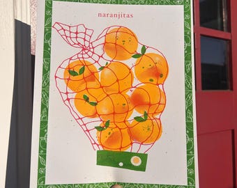 Puede incluir: Una impresión que presenta naranjas en una bolsa de red roja, con la palabra "naranjitas" en la parte superior. La impresión tiene un borde verde con un patrón repetido y la palabra "FRUTA" en un rectángulo verde.