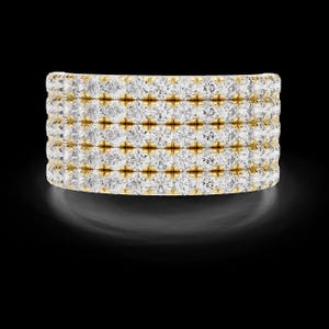 May include: A wide, gold band ring set with multiple rows of sparkling, round-cut diamonds. The ring is displayed against a black background, highlighting the brilliance of the gemstones.