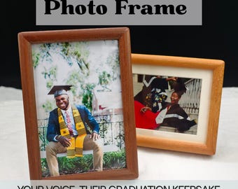 Pode incluir: Duas molduras de fotos de madeira, uma castanha escura e outra castanha clara, exibindo fotos de formatura. A moldura escura apresenta um homem com chapéu e toga de formatura. O texto na parte superior diz "Custom Voice Photo Frame" e na parte inferior, "YOUR VOICE, THEIR GRADUATION KEEPSAKE."