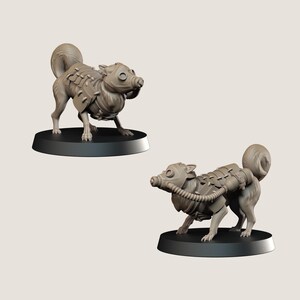 May include: Two miniature figurines of a dog-like creature with a gas mask and armour. The figurines are light brown and stand on black circular bases. The creature has a curled tail and a detailed, mechanical design.