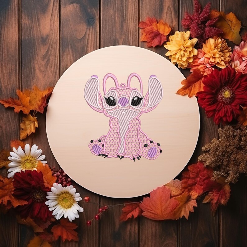 Puede incluir: Un dise&ntilde;o bordado en rosa del personaje Stitch sobre una placa de madera redonda. El dise&ntilde;o presenta un contorno detallado y patrones de panal. La placa est&aacute; rodeada de hojas de oto&ntilde;o y flores en tonos rojos, naranjas y amarillos.
