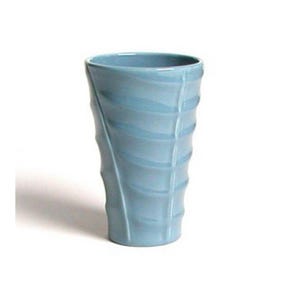 May include: A light blue ceramic vase with a unique, textured design. The vase has a cylindrical shape with vertical ridges and curved lines, creating a visually interesting pattern. The vase is approximately 7 inches tall.