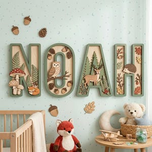 Könnte beinhalten: Holzwandkunst mit dem Namen "NOAH" in grünen Rahmen mit Ausschnitten zum Thema Wald. Die Buchstaben zeigen eine Eule, ein Reh, einen Igel, Pilze und Eicheln. Dekorative Akzente sind ein Kinderbett, ein Stofffuchs und ein Teddybär.