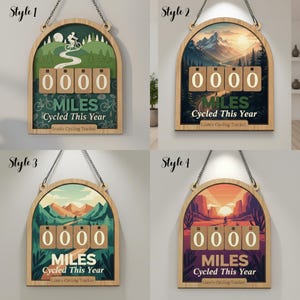 May include: Wooden cycling tracker with a decorative arched frame. The tracker displays "0000 MILES Cycled This Year". The background features a landscape scene with a cyclist. The tracker is suspended by a chain.
