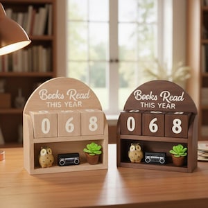 Może przedstawiać: Dwa drewniane liczniki książek z napisem "Books Read This Year". Każdy licznik wyświetla numer "068". Liczniki mają p&oacute;łkę z małą figurką sowy, miniaturowym radiem i doniczkową sukulentem.