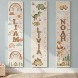 May include: Three wooden growth charts with names and decorative illustrations. One chart has a rainbow theme with the name "Liam". Another features dinosaurs and the name "Livia". The third chart has a forest theme with the name "Noah". Each chart has inch and centimeter markings.
