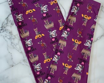May include: Purple leggings with a repeating pattern of Chihuahuas, sunflowers, and baskets. The text "I love my Chihuahua" is also printed on the leggings. The leggings are made of a soft, stretchy material.