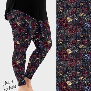 May include: Leggings with a dark floral pattern featuring burgundy roses, blue and yellow flowers, and green leaves. The leggings have a black background and the text "I have pockets" is visible on the side.