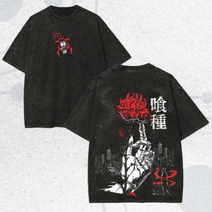Puede incluir: Camiseta negra con aspecto desgastado. La parte delantera presenta un gráfico rojo y blanco de una figura arácnida. La parte trasera muestra una gran flor roja, una mano esquelética y texto japonés. Un paisaje urbano y detalles rojos completan el diseño.