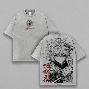 Op de afbeelding: Twee grijze t-shirts. Eén shirt heeft een zwarte bloem en de rode tekst "Jigokuraku". Het andere heeft een grote zwart-wit anime-stijl afbeelding op de achterkant met Japanse tekst in het rood.