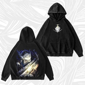 May include: Two black hooded sweatshirts. One features a graphic of a knight with a sword, the other has a white and yellow design. Both sweatshirts have a front pocket and a hood. The sweatshirts are made of a soft, comfortable material.