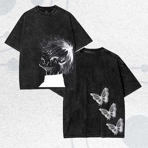 Puede incluir: Dos camisetas negras con un aspecto vintage descolorido. Una tiene un gráfico blanco de un perfil, la otra presenta tres ilustraciones de mariposas blancas. Ambas tienen mangas cortas y cuello redondo.