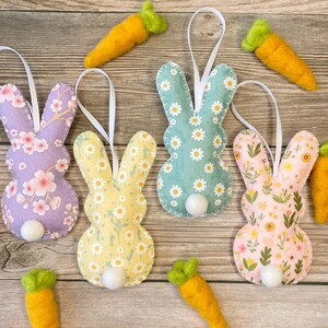 Pu&ograve; includere: Quattro ornamenti di coniglio in feltro con diversi motivi floreali. Ogni coniglio ha una coda di pon pon bianca e un anello di nastro bianco per appenderlo.
