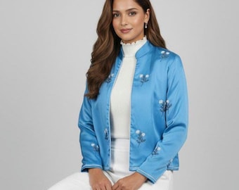 Blazer azul de seda com estampa floral e aplicações de miçangas, ideal para usar à noite.