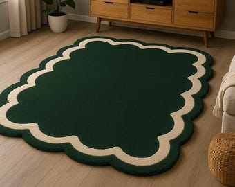 May include: A dark green, cloud-shaped rug with a cream-colored scalloped border. The rug is placed on a light-colored hardwood floor. The rug's unique shape and color scheme add a touch of elegance to the room.