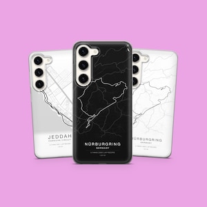 Könnte beinhalten: Drei Handyhüllen mit Kartendesigns. Die mittlere Hülle ist schwarz mit einer weißen Karte von Nürburgring, Deutschland. Die anderen beiden Hüllen sind weiß mit Kartendesigns von Jeddah und Nürburgring. Jede Hülle hat einen Kameraausschnitt.
