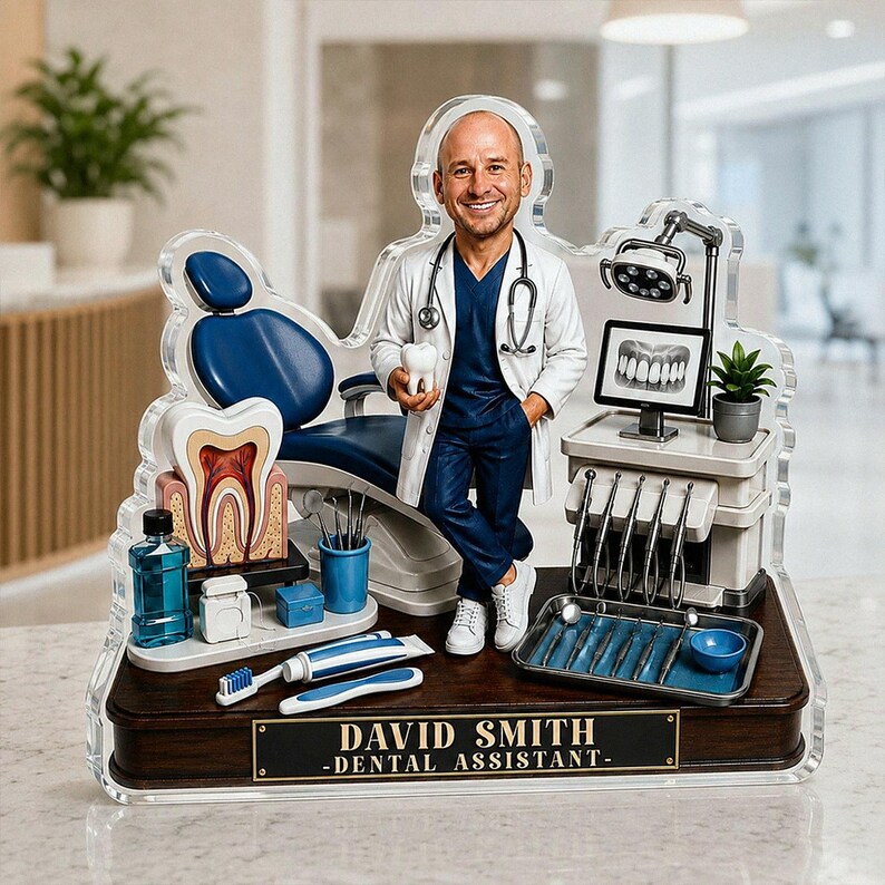 May include: A custom acrylic display featuring a miniature dentist figure holding a tooth model, standing next to a blue dental chair, a monitor showing an X-ray, and dental tools. A plaque on the dark wood base reads DAVID SMITH - DENTAL ASSISTANT.