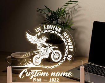 May include: A lit memorial sign featuring a motocross rider design. The sign reads "In Loving Memory Of" and includes space for a custom name and dates. The sign is made of clear acrylic and wood.