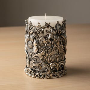 Pu&ograve; includere: Una candela a colonna bianca &egrave; all'interno di un portacandele in metallo argentato e ornato. Il supporto presenta un design floreale dettagliato con girasoli, gigli e altri fiori. Il portacandele misura circa 10 cm di diametro e 13 cm di altezza.