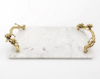May include: A rectangular marble serving tray with gold floral branch handles. The tray has a white background with grey veining. The handles are detailed with flowers and leaves, adding elegance to the serving piece.