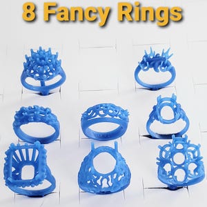 May include: Eight blue ring settings for jewelry making, arranged in a grid. Each ring features a distinct, intricate design with prongs for stone mounting. The text 8 Fancy Rings is displayed in yellow at the top of the image.