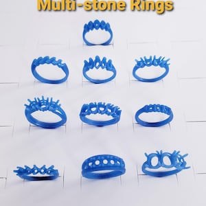 May include: A collection of ten blue wax ring models for jewelry casting, arranged in a grid. Each ring features multiple prongs or settings designed to hold stones. The text Multi-stone Rings is displayed at the top of the image.